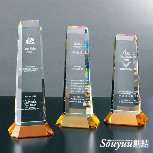 光学ガラス製表彰楯 SHSS-7246 台座にオレンジのカラーガラスを使用し朝日が昇るかのように、クリアガラスを照らします。底部にはレインボーミラー加工が施されているので台座のオレンジが一層光の輝きを広げてくれます。Aサイズは高さ300mm横幅115mm重さ2000g 32000円、Bサイズは高さ270mm横幅115mm重さ1900ｇ 28000円、Cサイズは高さ245mm横幅115mm重さ1800ｇ 25000円です。 