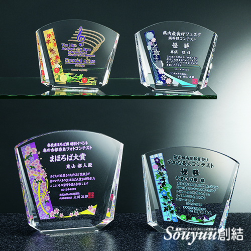 光学ガラス楯SHUS-7543 扇形の光学ガラス製の表彰楯に四季デザインをアレンジすることもできます。和風テイストが表彰シーンを優雅に演出します。Aサイズは高さ170mm横幅200mm 重量：約1.700g 30000円、Bサイズは高さ150mm横幅180mm 重量：約1.200g 25000円、Ｃサイズは高さ130mm横幅160mm 重量：約880g 20000円です。